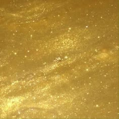 an image of some gold glitter in the air with stars and bubbles on it's surface