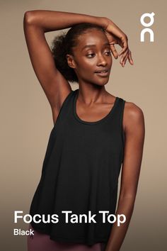 a woman in black tank top with her hands on her head and the words focus tank top