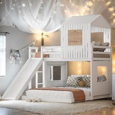 a child's bedroom with a bunk bed and slide in the corner, lights strung up on the ceiling