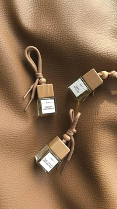 three small square boxes tied together on a brown leather surface with two tags attached to them