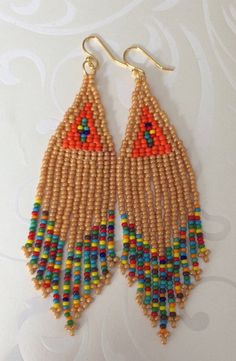 Handmade beaded long beige and multicolored seed bead earrings. Stunning handmade beaded earrings made with beige, orange and super bright multicolored 11/0 seed beads. The earrings have long flowing multicolored fringe. The french hook earwires and findings are sterling silver. These gorgeous Cheyenne style earrings are super long and brush your shoulders ever so slightly. Great for daywear and stunningly beautiful for the night out. Earrings measure approximately 4.5 inches including ear wires Colorful Beaded Brown Earrings For Beach, Brown Beaded Earrings For The Beach, Beach Beaded Earrings With Colorful Beads, Traditional Multicolor Beaded Earrings With Gold Beads, Beige Jewelry With Colorful Beads For Festivals, Beige Festival Jewelry With Colorful Beads, Bohemian Brown Beaded Earrings With Gold Beads, Beige Dangle Jewelry With Colorful Beads, Beige Beaded Earrings For The Beach