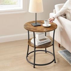 a small table with a lamp on top of it next to a couch and chair