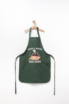 an apron hanging on a wooden hanger that says baking is mementoal bake down