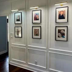 a wall with several pictures hanging on it's sides and some wood flooring