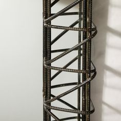 a tall metal rack with several shelves on it's sides, against a white wall