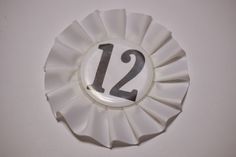 a white plate with the number twelve on it and a silver circle around it that reads 12 / 2