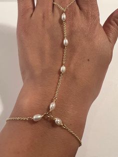 This genuine Pearl hand chain is Stunning and made by hand using genuine Swarovski rhinestones and crystals, 14k gold fill chain and clasp. Made for the Ti Adora by Alvina Valenta 2016 NY Bridal Market and LookBook photoshoot. Typical made for a 7" long hand (wrist to top of center finger):6.5" in wrist circumference with .5" additional adjustable clasp.3" from wrist up to the ring2.5" in ring loop circumference (non adjustable)Custom length is welcome! Just write in the measurements in the note Bracelet Connected To Ring, Ring To Bracelet Jewellery, Diy Hand Chain, Hand Chain Bracelet Gold, Chain Ring Bracelet, Gold Hand Chain, Lookbook Photoshoot, Hand Chain Jewelry, Finger Bracelets