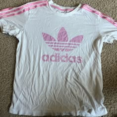 Size: Medium Color : Pink And White Brand: Adidas Condition: Never Worn It Looks Like That Because It Was In My Bin And Got Wrinkled But Other Than That Never Been Worn And In Good Condition No Stains And No Tears Material: Really Soft Adidas Three Stripes T-shirt For Spring, Trendy Adidas T-shirt With Letter Print, Trendy Adidas T-shirt For Spring, Adidas Logo Tops, Adidas Logo Tops For Spring, Summer Crew Neck Top With Three Stripes Branding, Summer Three Stripes Crew Neck Tops, Summer Adidas Logo Top, Adidas Logo Summer Top