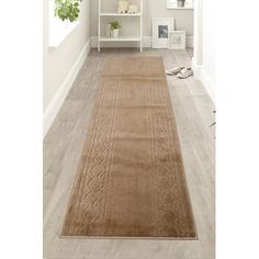 a beige rug is on the floor in front of a white shelf with bookshelves