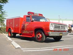 an old red fire truck parked in a parking lot