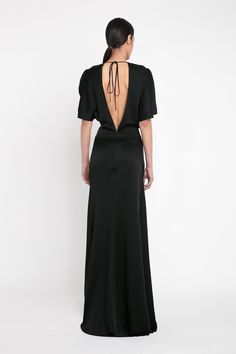 The classic black evening dress is elevated with the house’s signature attention to detail. Crafted from luxurious crepe back satin, the Gathered Waist Floor-Length Dress in Black has a provocative open back design, tactile tie detail at the back of the neck and sensuous pleating at the front of the skirt. Cut to fit and flatter the upper body before pooling into a floor-grazing hemline, it exudes contemporary sophistication. Victoria Beckham Gathered Waist Floor-Length Dress In Black  - Size 14 Luxury Satin Finish Gown For Formal Occasions, Luxury Satin Finish Formal Gown, Silk Evening Dresses With Pleated Back, Silk Dress With Satin Finish For Evening, Luxury Satin Finish Evening Dress For Formal Occasions, Silk Maxi Dress With Pleated Back For Cocktail, Satin Evening Dress With Pleated Back, Silk Evening Dress With Pleated Back For Cocktail, Silk Evening Dress With Back Opening For Cocktail