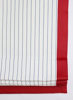 the red and white striped fabric is folded on top of each other with blue pins