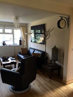 a living room filled with furniture and a clock on the wall