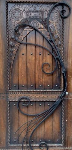 an old wooden door with iron work on it