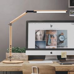 an apple computer sitting on top of a desk next to a lamp and other items