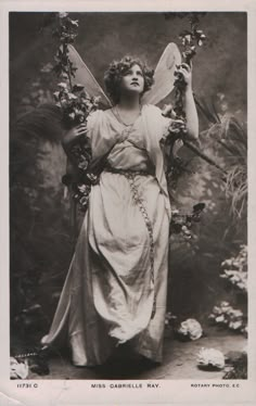 an old black and white photo of a woman holding flowers