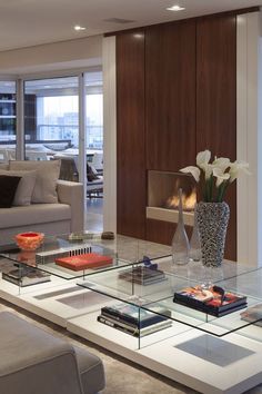 a living room with glass tables and couches