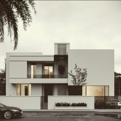 a car parked in front of a tall white building with windows and balconies