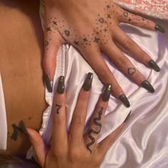 two hands with black and white nail designs on them, one is holding the other