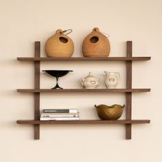 three wooden shelves with vases and books on them