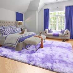 a bed room with a neatly made bed and purple rugs