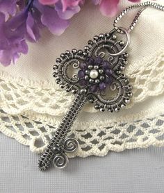 a close up of a piece of jewelry on top of a lace covered table cloth