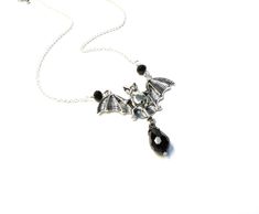 Silver bat necklace with black glass drop! Handmade. product details On a 18 inch (35.56 cm) silver plated chain with 3 inch (10.16 cm) extender chain. Bat is silver plated. 2 inches wide (5.08 cm) Faceted black glass drop I hope you enjoy my handmade creations and please visit the rest of my shop for items: https://www.etsy.com/shop/AnEnchantingCreature Thank you for supporting small business VISIT MY SHOPS HERE * http://www.etsy.com/shop/HappyCatHouse * http://www.Etsy.com/shop/AnEnchantingCre Gothic Nickel-free Necklaces For Halloween, Gothic Nickel-free Necklace For Halloween, Black Vampire Jewelry For Halloween, Vampire Style Black Jewelry For Halloween, Gothic Dangle Necklaces For Halloween, Gothic Dangle Halloween Jewelry, Gothic Dangle Jewelry For Halloween, Adjustable Black Vampire Style Necklaces, Adjustable Black Vampire Necklace