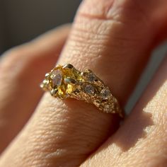 a close up of a person's hand with a yellow diamond ring on it