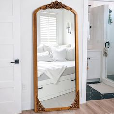 a large mirror sitting on top of a wooden floor