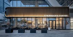 starbucks coffee is located in the middle of a large building with glass walls and windows