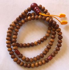 This small sandal wood mala has three traditional decoration beads and guru beads. It is from Nepal and nice and beautiful mala. it is 11 inches long mala. Brown Bohemian Mala For Puja, Traditional Brown Beaded Bracelets With Large Beads, Traditional Brown Beaded Bracelet With Large Beads, Traditional Brown Mala For Meditation, Traditional Brown Mala For Rituals, Brown Mala For Healing And Festivals, Traditional Wooden Bracelets With Round Beads, Traditional Wooden Bracelet With Round Beads, Handmade Brown Mala For Rituals