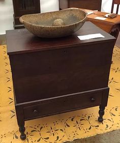 a bowl sitting on top of a wooden cabinet