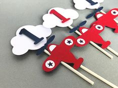 red, white and blue airplane cupcake toppers on sticks with clouds in the background