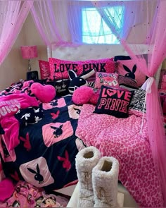 a bed with pink and blue comforters, pillows, and blankets on top of it