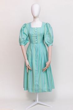 A beautiful aqua green dress with pale stripe pattern in traditional Austrian style, made of high quality cotton. Puff sleeves, square neckline, raised shoulders, buttoned from the front.  Midi length. Fabric: 100% cotton Condition: Very good vintage condition, no stains or holes. Freshly laundered and ready to wear. Measurements: Best fit: XXS-XS | EU34 | UK6 | US 4 All measurements are taken lying flat and have already been doubled Shoulders: 36cm / 14'' Sleeves: 32cm / 12,5'' Chest: 84 cm / 3 Cotton Puff Sleeve Dress With Square Neck For Daywear, Cotton Square Neck Puff Sleeve Dress For Daywear, Green Fitted Cotton Puff Sleeve Dress, Fitted Green Cotton Puff Sleeve Dress, Cotton Puff Sleeve Dress With Square Neck, Green Cotton Dress With Gathered Sleeves, Fitted Cotton Puff Sleeve Dress With Square Neck, Green Cotton Puff Sleeve Dress, Green Cotton Puff Sleeve Short Dress