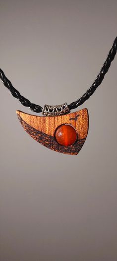 "Surprise your friend or enrich your outfit with unique handmade wooden necklace with a gemstone. It is made of African Bodo wood and charming Agate Stone. Buying this wooden pendant you will get a stone-talisman of strength and wellbeing for all the life. Sunset Ocean inspiration is what our Sunset Ocean pendant symbolises. This unique bodo wood pendant with its unusual shape immerses you in a world of nautical adventure and endless horizons. The agate stone in the center of the pendant, which rotates around its axis, represents the sun at sunset. Agate symbolises strength, harmony and poise, while the bodo tree symbolises resilience and the natural beauty of nature.  PENDANT SIZE:  26*36mm  NECKLACE LENGTH: 45 cm the width 3 mm \"Sunset Ocean\" is not just a piece of jewellery - it is a Handmade Natural Wood Pendant Jewelry, Unique Natural Wood Pendant Jewelry, Handmade Wooden Pendant Jewelry, Amber Necklace With Wooden Beads For Gifts, Gift Wooden Bead Necklaces In Natural Wood, Natural Wood Necklaces With Wooden Beads For Gift, Orange Jewelry With Wooden Beads As A Gift, Orange Jewelry With Wooden Beads For Gifts, Bohemian Wood Necklace For Gift