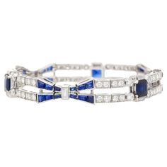 Indulge in the timeless allure of Art Deco with our stunning Blue Sapphire and Diamond Bracelet set in platinum. This exquisite piece embodies the essence of Art Deco design, boasting a perfect blend of quintessential Art Deco symmetry and vibrant contrast. The captivating blue sapphires and dazzling diamonds are meticulously arranged in a symmetrical geometric pattern, echoing the era's iconic style. The focal point showcases three stunning Emerald-cut Blue Sapphires, totaling 4 carats. Complem Timeless Blue Bracelet For Formal Occasions, Luxury Blue Diamond Bracelet, Formal Blue Bracelet With Polished Finish, Blue Bracelets With Polished Finish For Formal Occasions, Luxury Blue Sapphire Bracelets, Luxury Sapphire Tennis Bracelet For Formal Occasions, Luxury Sapphire Bracelet For Formal Occasions, Luxury White Gold Sapphire Diamond Bracelet, Timeless Blue Diamond Bracelet