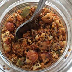 a glass jar filled with lots of food and a spoon sticking out of the top