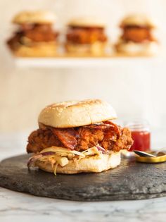 a chicken burger sitting on top of a table next to a cup of ketchup