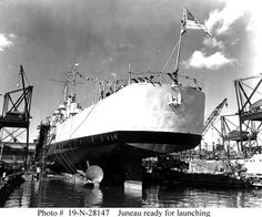 an old photo of a large ship in the water with cranes around it and a flag on top