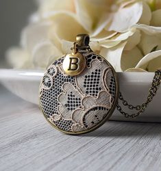 "The classic look of this lace pendant with initial charm makes it the perfect, personalized gift for her - this necklace is handmade with vintage beige lace that is actually antique in age since it's from the 1920s. It is made of cotton, as well as the black background fabric that is behind the lace. The gold and black capital letter initial charm makes this a unique way to personalize the necklace as an anniversary gift for your wife or loved one's 13 year anniversary, which is the material la Vintage Handmade Beige Jewelry, Vintage Round Pendant Necklace For Personalized Gift, Vintage Jewelry Initial Pendant For Personalized Gift, Vintage Round Necklaces For Personalized Gifts, Vintage Personalized Initial Pendant Necklace, Handmade Vintage Necklace For Personalized Gift, Vintage Handmade Necklaces For Personalized Gifts, Handmade Vintage Necklaces For Personalized Gifts, Vintage Beige Necklace For Gift