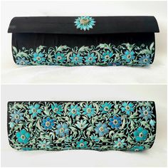 "The perfect wedding purse! A sophisticated and feminine black silk clutch bag, expertly hand embroidered by zardozi artisans. A profusion of petit blue silk flowers are inlaid with emerald gemstones. Each delicate petal and leaf is meticulously outlined with a glittery silver metallic thread, to give a sparkly, opulent 3D effect. Crowned by a beautifully embroidered blue medallion with an emerald cabochon. The word Zardozi means \"gold thread\". It is an elaborate and intricate embroidery art f Black Hand Embellished Clutch For Wedding, Elegant Festive Clutch With Floral Embroidery, Traditional Embroidered Evening Potli Bag, Festive Evening Clutch With Intricate Embroidery, Festive Floral Embroidery Evening Bag, Traditional Evening Potli Bag With Intricate Embroidery, Traditional Embroidered Potli Bag For Evening, Traditional Black Evening Bag For Wedding, Rectangular Clutch With Resham Embroidery For Reception