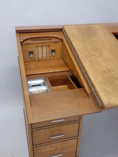 an old wooden desk with two drawers and one drawer open to show the contents inside