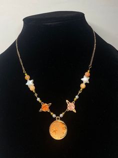 This celestial necklace features gold hardware, carnelian beads, pearl accents, and pink coral charms! Gold Necklaces With Star Charm And Round Beads, Gold Necklace With Star Charm And Round Beads, Celestial Gold Beaded Jewelry, Gold Necklaces With Moon Charm And Round Beads, Celestial Necklace, Carnelian Beads, Pink Coral, Beaded Necklaces, Gold Hardware