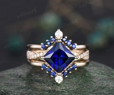 an engagement ring with blue sapphire and diamond accents on top of a green marble slab