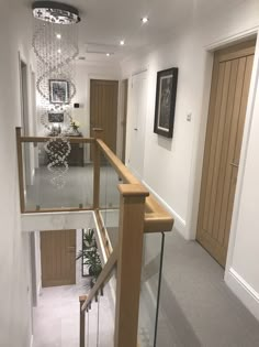 a staircase with glass railing and wooden handrails in a home's entryway