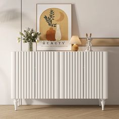 a white radiator sitting on top of a wooden floor next to a painting