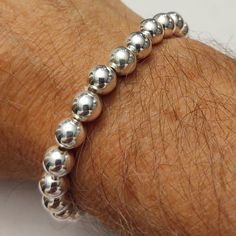 "These are very unique bracelets made from genuine metal beads.  This one has heavy, hollow 8mm sterling silver beads.  The length averages around 7\".  It is stretchy though, so it will probably fit between 6.5\" and 7.5\".  Larger and smaller size available upon special request. (Send me a note.) The beads are genuine and solid Sterling Silver.  There may be tiny dents on close inspection.  It can't be helped.  Do not drop or allow to bang against hard surfaces. These bracelets are extremely beautiful and can be worn by both men and women!" Everyday Silver Bead Stretch Bracelet, Hypoallergenic Sterling Silver Stretch Bracelet In Silver, Silver Spiritual Stretch Bracelet For Everyday, Hypoallergenic Sterling Silver Stretch Bracelet, Silver Spiritual Stretch Bracelet, Spiritual Silver Stretch Bracelet, Silver Hand-strung Stretch Bracelet, Classic Silver Round Beads Stretch Bracelet, Classic Silver Hypoallergenic Stretch Bracelet