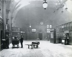 an old black and white photo of people in a large room with many bookshelves