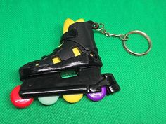 a toy roller skate keychain is shown on a green surface with colorful balls